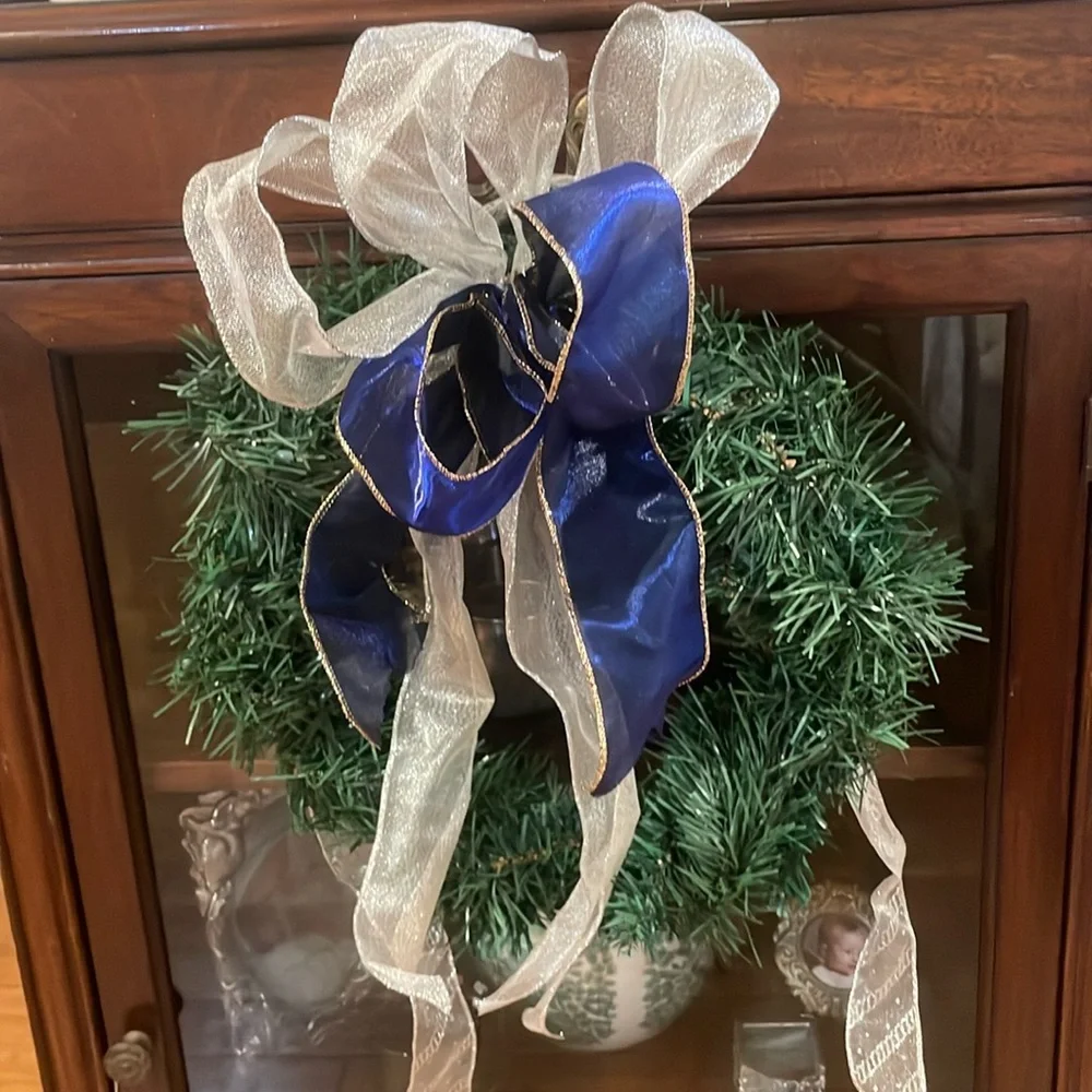 Green Christmas holiday wreath with blue and silver ribbon